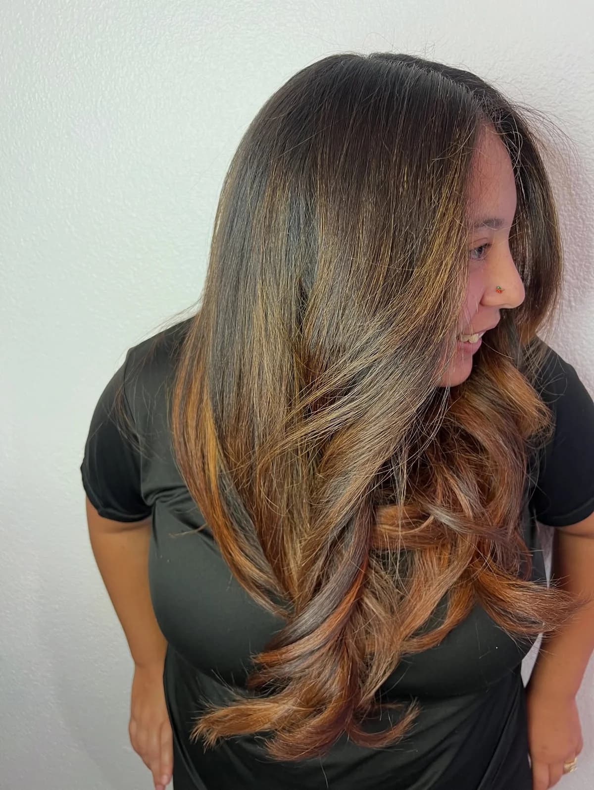 Finished dark-to-light balayage with softly layered warm-toned lengths, viewed from the side