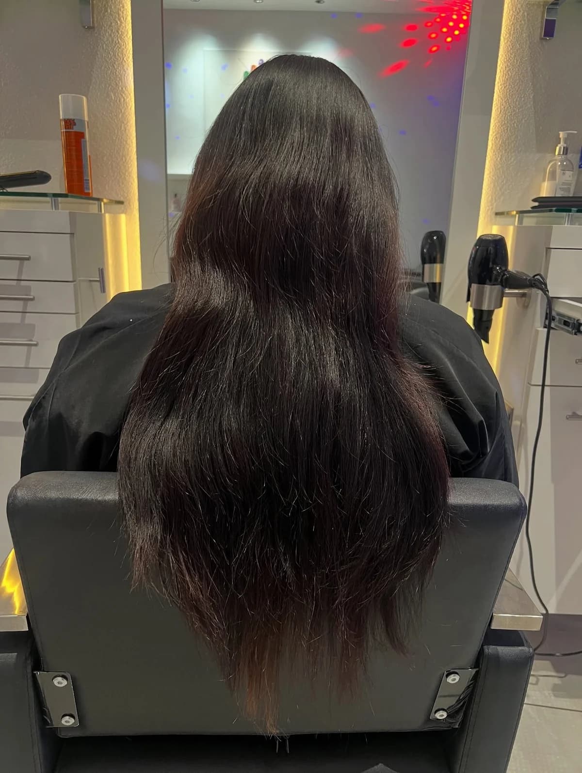 Long dark hair before the dark-to-light balayage service, viewed from behind