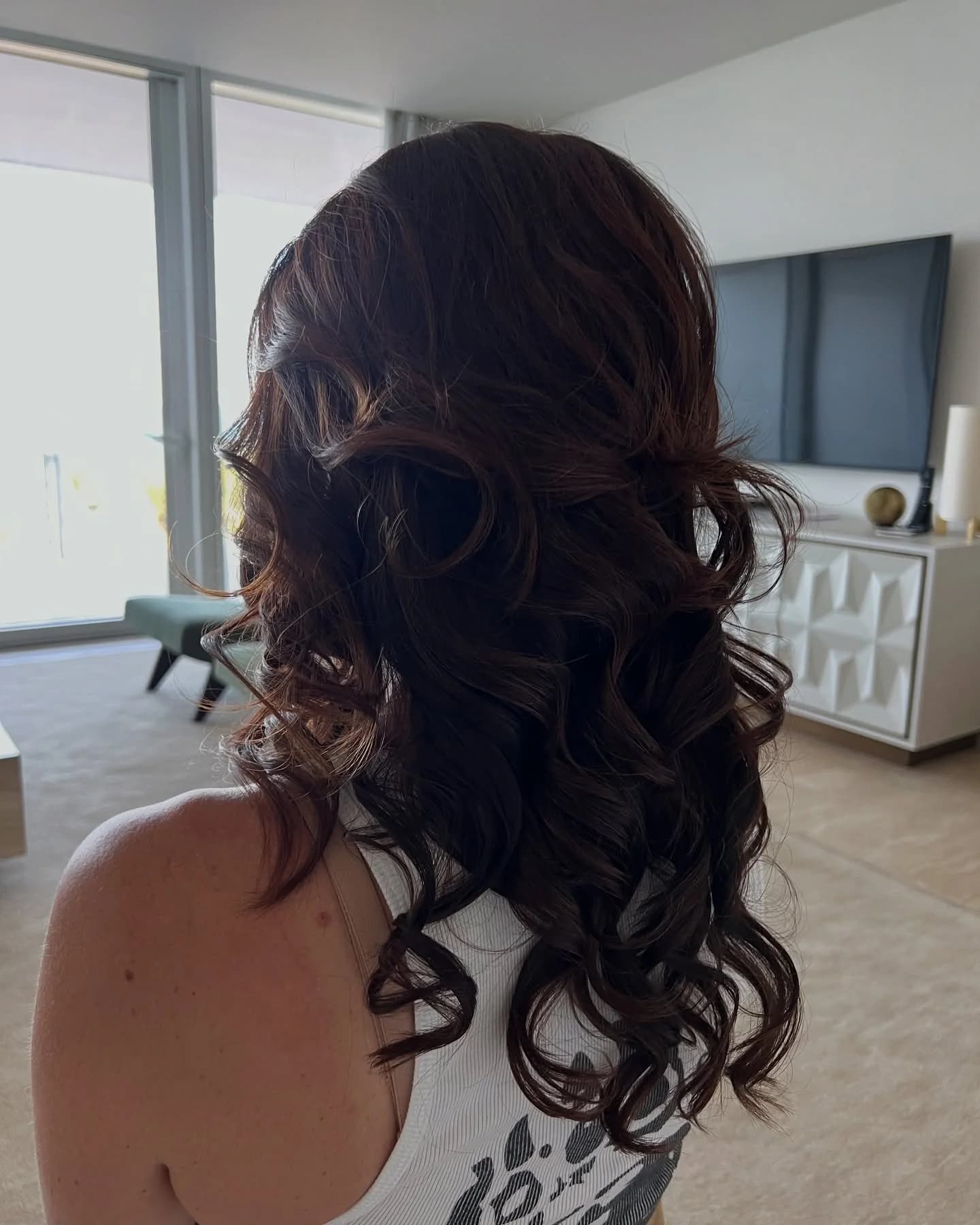 Dark brunette curls styled with natural movement, seen from behind
