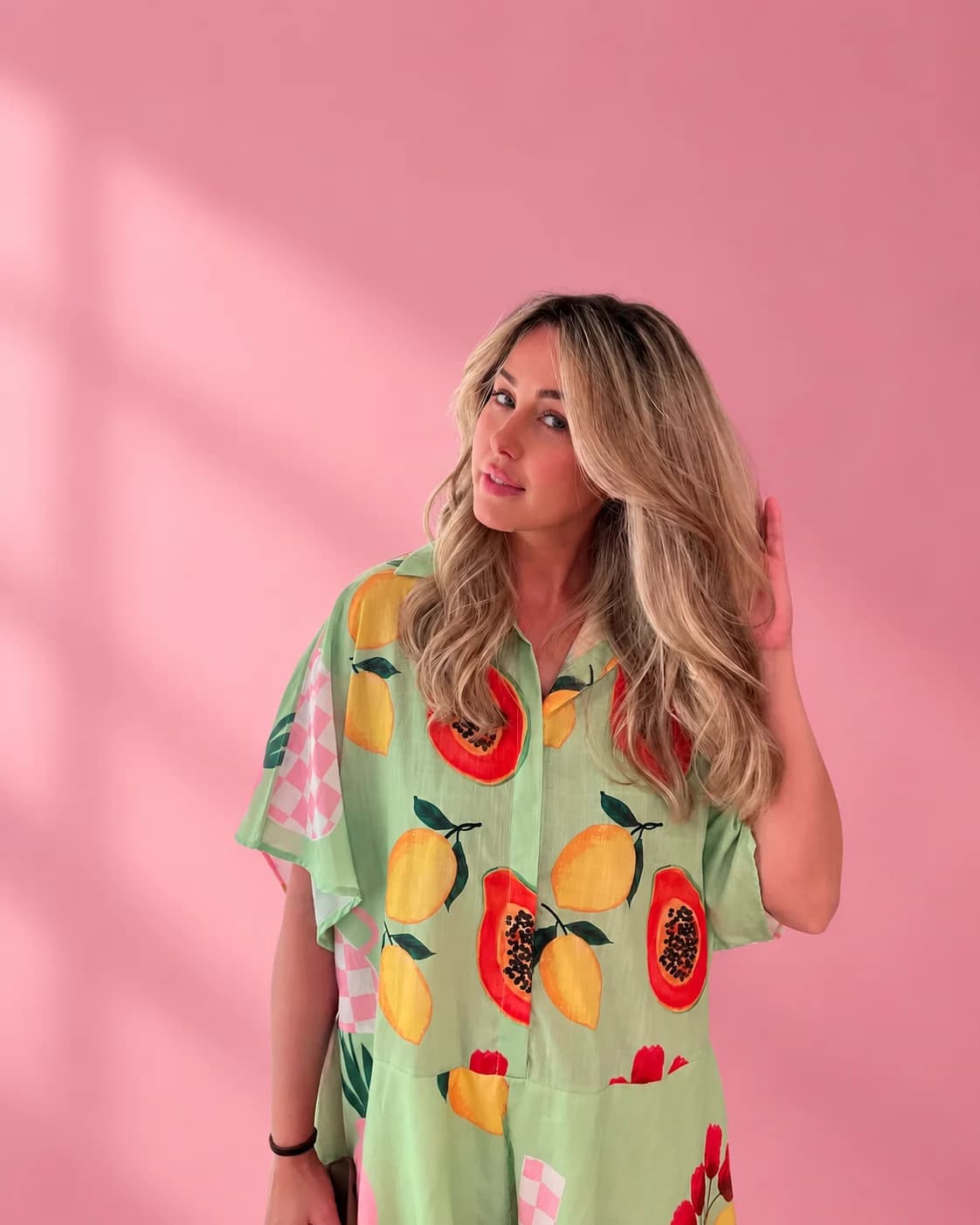 Woman with a voluminous blonde blowout against a pink background