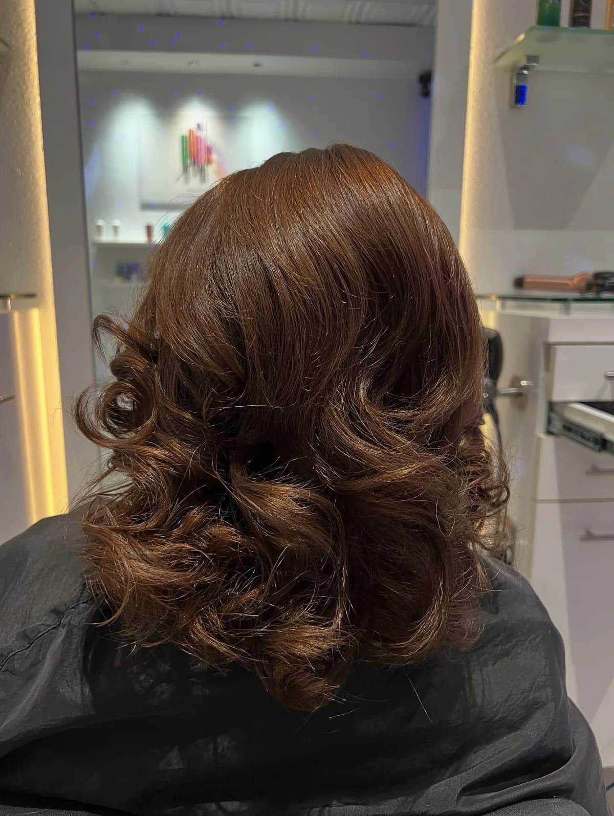 Chestnut hair styled with soft curls, photographed from behind