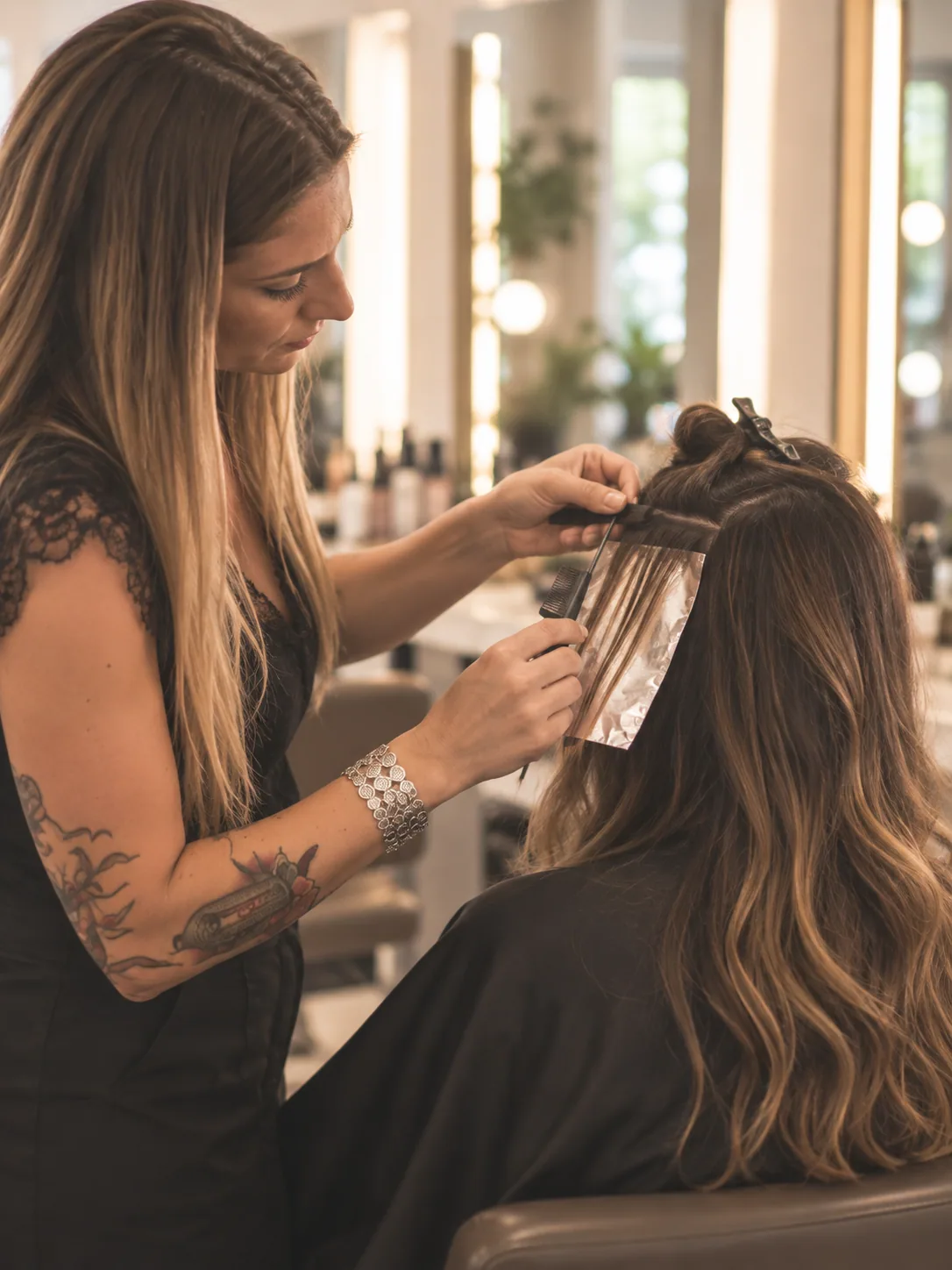 Hair colorist applying highlights to a client's hair