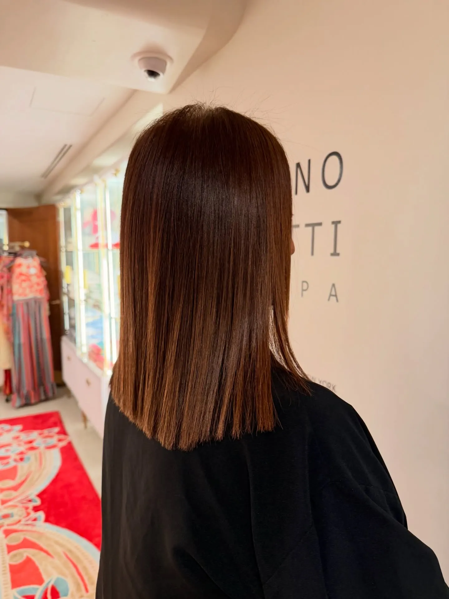 Sleek, straight chestnut hair cut to a blunt line below the shoulders