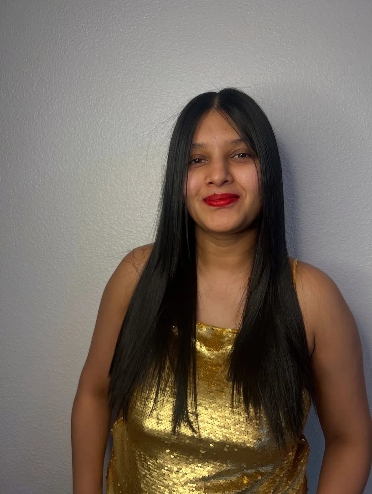 Client wearing a gold top with long straight dark hair, photographed from the front